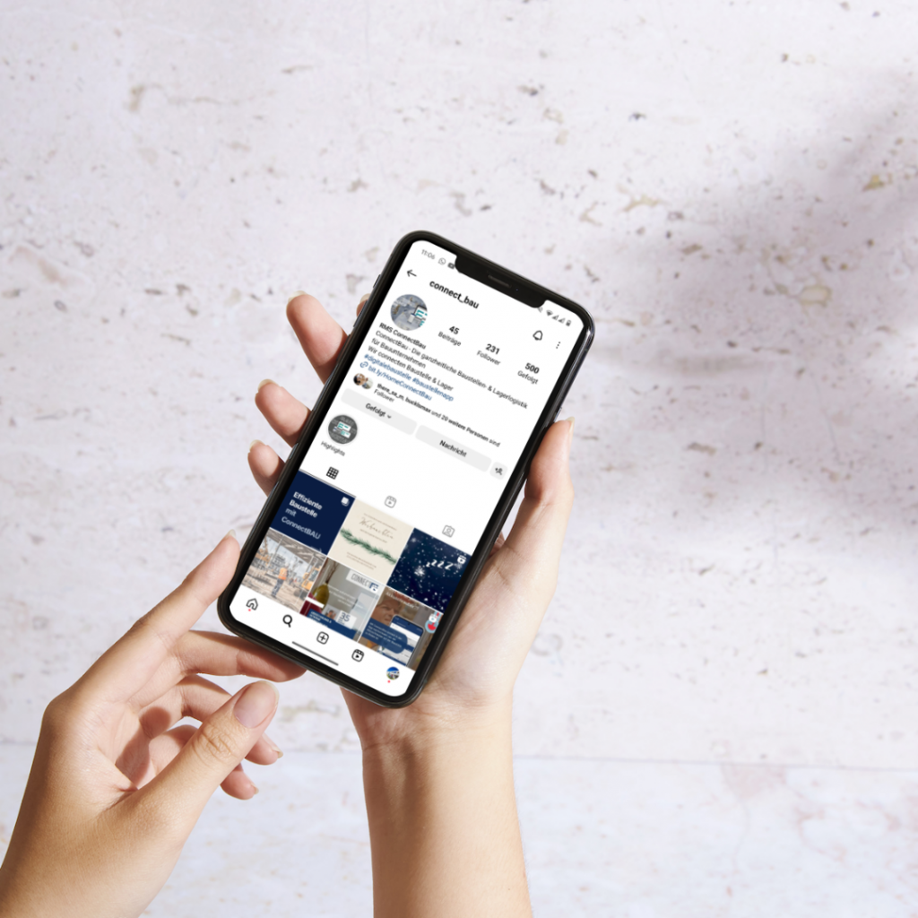 Jemand hält ein Smartphone mit ConnectBaus Instagram Profil